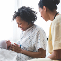 Nurse and mother admiring newborn baby